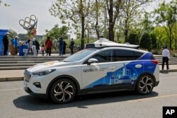 Taksi swakemudi, Baidu Apollo Robotaxi, melewati konter layanan pelanggannya di Taman Shougang, Beijing, Minggu, 2 Mei 2021. (AP/Andy Wong, File)