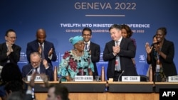 2022年6月17日，世界贸易组织总干事伊韦阿（中左）在日内瓦世贸组织总部举行的世界贸易组织部长级会议闭幕式后，会议主席苏莱梅诺夫（右二）在旁边鼓掌。