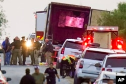 FILE - Police and other first responders work the scene where dozens of people died and others were hospitalized with heat-related illnesses after a semitrailer containing suspected migrants was found, June 27, 2022, in San Antonio.