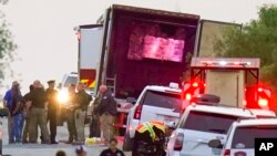 FILE - Police and other first responders work the scene where dozens of people died and others were hospitalized with heat-related illnesses after a semitrailer containing suspected migrants was found, June 27, 2022, in San Antonio.