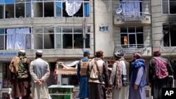 Taliban fighters gather at the site of an explosion in front of a Sikh temple in Kabul, Afghanistan, June 18, 2022. Several explosions and gunfire ripped through the temple in Afghanistan's capital.