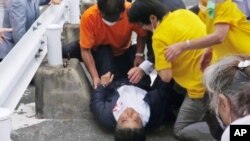 En esta imagen de un video, el ex primer ministro de Japón, Shinzo Abe, en el centro, es atendido en Nara, en el oeste de Japón, el viernes 8 de julio de 2022. (Noticias de Kyodo vía AP)