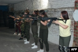 Las mujeres aprenden a usar rifles de asalto Kalashnikov, 17 de junio de 2022, en Zaporizhzhia, sureste de Ucrania, en un centro de capacitación de seguridad donde los expertos las instruyen en tácticas de combate urbano.