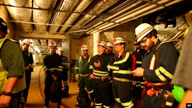 Researchers at the Sanford Underground Research Facility in Lead, S.D., discuss conditions on Dec. 8, 2019 at the underground laboratory that was once used as a gold mine. (AP Photo/Stephen Groves)