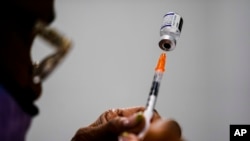 A health worker preparing the a Pfizer vaccine.