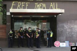 FILE- Polisi berjaga di luar hotel tahanan pengungsi, Park Hotel di Melbourne, Australia, Sabtu, 8 Januari 2022. Australia mendapat kecaman tajam internasional atas perlakuannya terhadap para pengungsi. (Foto AP/Hamish Blair)