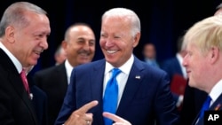 From left, Turkish President Recep Tayyip Erdogan, U.S. President Joe Biden and British Prime Minister Boris Johnson converse at a NATO summit in Madrid, Spain, June 29, 2022.