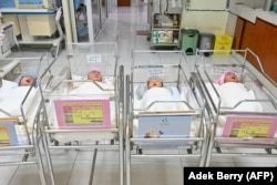 Bayi baru lahir terlihat mengenakan pelindung wajah sebagai pelindung di tengah pandemi COVID-19, terlihat di fasilitas bersalin di Jakarta pada 21 April 2020. (Foto: AFP/Adek berry)