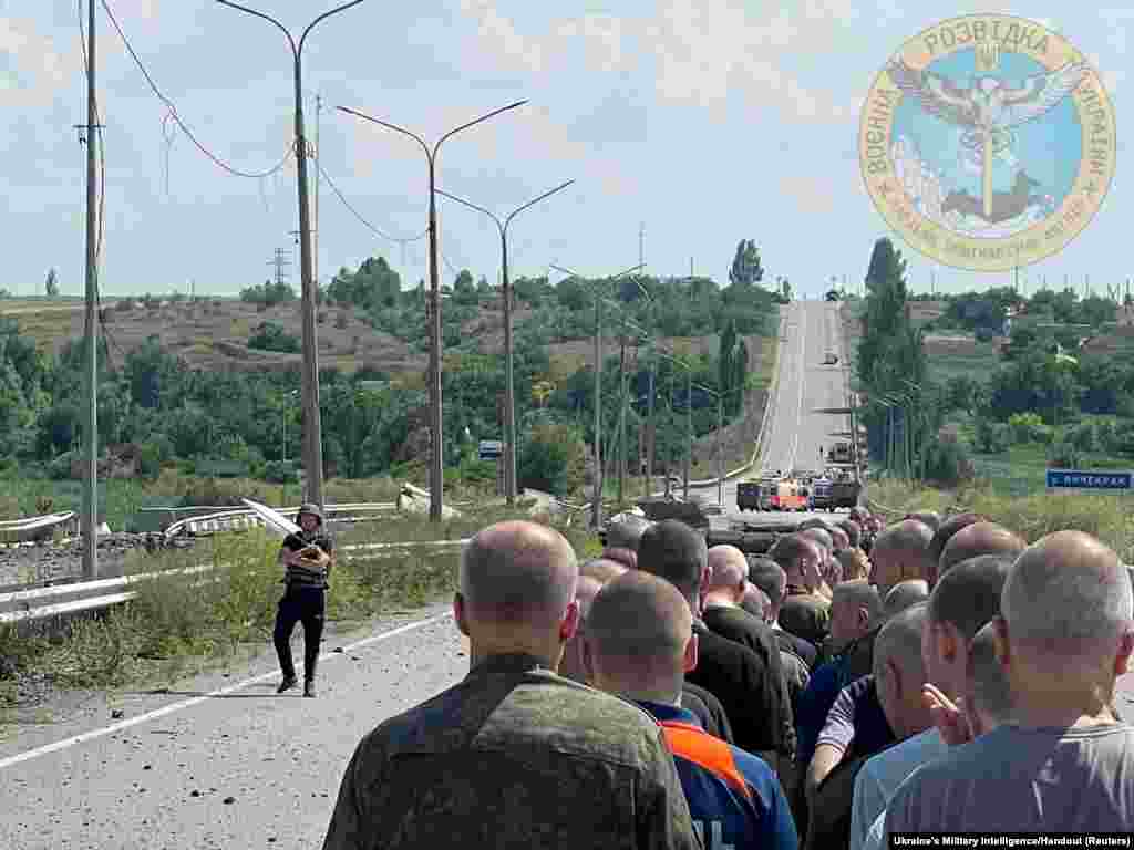 A man with a white flag walks along the road during an exchange of prisoners&nbsp;at a location given as Zaporizhzhia region of Ukraine, as Russia&#39;s attack on Ukraine continues, June 29, 2022.