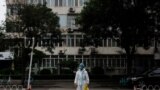 Un trabajador médico con traje protector cruza una calle tras un brote de la enfermedad del nuevo coronavirus en Beijing, el 6 de julio de 2022.