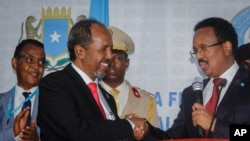 FILE - Hassan Sheikh Mohamud, left, shakes hands after his election win with incumbent leader Mohamed Abdullahi Mohamed, right, at the Halane military camp in Mogadishu, on May 15, 2022.