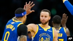 Golden State Warriors guard Stephen Curry (30) high fives Golden State Warriors guard Gary Payton II (0) during the second quarter of Game 6 of basketball's NBA Finals against the Boston Celtics, June 16, 2022, in Boston. 