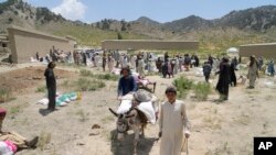 Afghans receive aid at a camp after an earthquake in Gayan district in Paktika province, June 26, 2022.