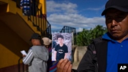 A man shows a portrait of Wilmer Tulul, in Tzucubal, Guatemala, June 29, 2022. Wilmer and his cousin were among the dead discovered inside a semitrailer on the edge of San Antonio, Texas, on June 27, in a deadly case of human smuggling.