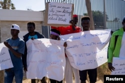 FILE - Protesters gather outside Melilla's short-stay migrants center CETI after at least 23 migrants died trying to reach the Spanish enclave, in Melilla, Spain, June 27, 2022.