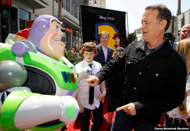 Aktor Tom Hanks (kanan) berinteraksi dengan karakter Buzz Lightyear (kiri) saat ia tiba di pemutaran perdana dunia "Toy Story 3" Disney Pixar di Teater El Capitan di Hollywood, California, 13 Juni 2010. (Foto: REUTERS/Danny Moloshok )