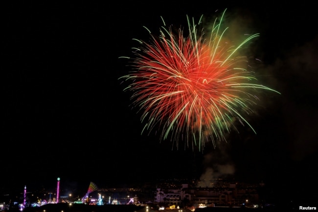 La gente celebra el feriado del Día de la Independencia del 4 de julio mientras los fuegos artificiales estallan sobre la Feria del Condado de San Diego, en Del Mar, California, EEUU, el 4 de julio de 2022.