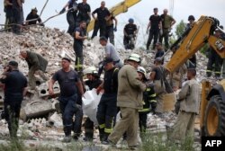 Rescuers carry the body of a man after a building was partially destroyed following shelling in Chasiv Yar, eastern Ukraine, on July 10, 2022.