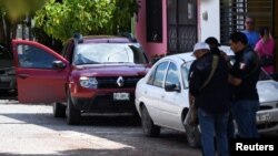 Police officers stand near the vehicle of journalist Antonio de la Cruz, who was killed by unknown assailants while leaving his home, in Ciudad Victoria in Tamaulipas state, Mexico, June 29, 2022.