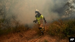 A firefighter works in the San Martin de Unx area in northern Spain, June 19, 2022. Firefighters in Spain are struggling to contain wildfires in several parts of the country which as been suffering an unusual heat wave for this time of the year.