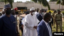 Nigeria's President Muhammudu Buhari, center, visits the medium-security prison that was attacked by several gunmen in Kuje, near Abuja, Nigeria July 6, 2022. 