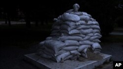 La escultura del poeta italiano Dante Alighieri está protegida por sacos de arena en el parque Vladimir Hill en Kiev, Ucrania, el 23 de junio de 2022. (Foto AP/Nariman El-Mofty)