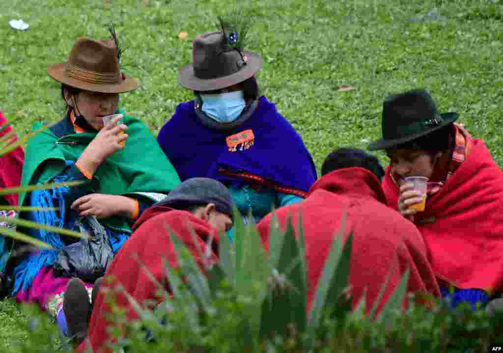 Indígenas toman algo para beber mientras descansan en los alrededores del edificio de la Asamblea Nacional, en Quito.&nbsp;