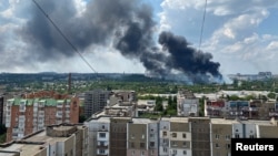 Smoke rises from the territory of an automotive center following recent shelling during Ukraine-Russia conflict in Donetsk, Ukraine, July 5, 2022. 