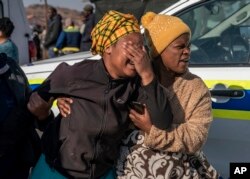 Une femme pleure sur les lieux de la fusillade survenue dans un bar à Soweto, en Afrique du Sud, le 10 juillet 2022.