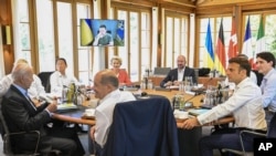 Para pemimpin G7 duduk di meja bundar di Castle Elmau di Kruen, dekat Garmisch-Partenkirchen, Jerman, menyimak pidato Presiden Ukraina Volodymyr Zelensky yang disampaikan melalui tautan video, 27 Juni 2022 (Tobias Schwarz/Pool via AP)