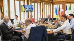 Para pemimpin G7 duduk di meja bundar di Castle Elmau di Kruen, dekat Garmisch-Partenkirchen, Jerman, menyimak pidato Presiden Ukraina Volodymyr Zelensky yang disampaikan melalui tautan video, 27 Juni 2022 (Tobias Schwarz/Pool via AP)