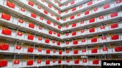 香港一座居民樓掛滿中國國旗和香港旗幟。（2022年6月26日）