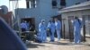 Forensic personnel investigate after the deaths of patrons found inside the Enyobeni Tavern, in Scenery Park, outside East London in the Eastern Cape province, South Africa, June 26, 2022. 