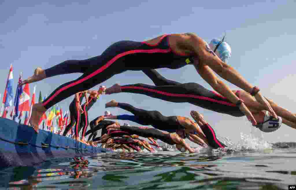 Swimmers take the start of the women&#39;s 10-kilometer open water swim event during the Budapest 2022 World Aquatics Championships at Lake Lupa in Budapest, Hungary.