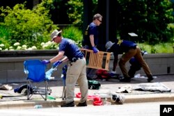 Members of the FBI's evidence response team remove personal belongings one day after a mass shooting in downtown Highland Park, Illinois, July 5, 2022.