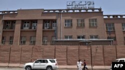 FILE - Afghan men walk past Da Afghanistan Bank, Afghanistan's central bank, in Kabul on June 28, 2011. 