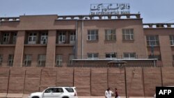 FILE - Afghan men walk past Da Afghanistan Bank in Kabul on June 28, 2011. 