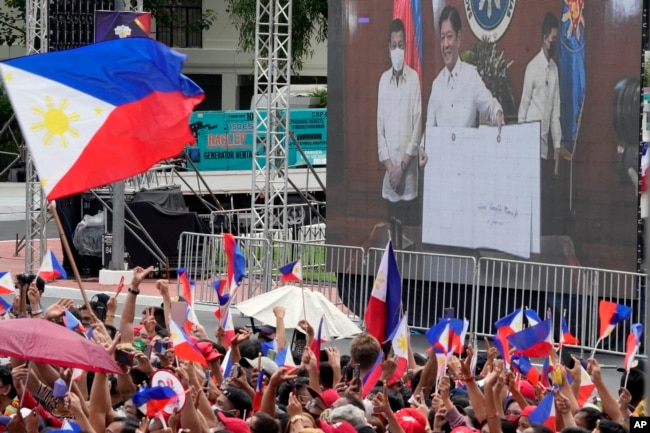 A screen shows incoming Philippine president Ferdinand Marcos Jr. and outgoing President Rodrigo Duterte at the inauguration ceremony venue at National Museum on Thursday, June 30, 2022 in Manila, Philippines. (AP Photo/Aaron Favila)