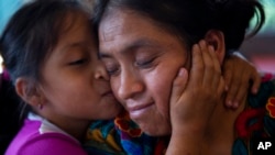 Astrid Cardona besa a su mamá Ufemia Tomás, madre de Yenifer Yulisa Cardona Tomás, durante una entrevista en Ciudad de Guatemala, el lunes 4 de julio de 2022. (AP Foto/Oliver de Ros)