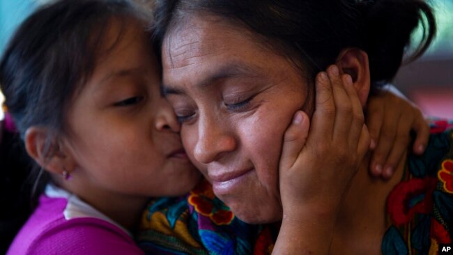 Astrid Cardona besa a su mamá Ufemia Tomás, madre de Yenifer Yulisa Cardona Tomás, durante una entrevista en Ciudad de Guatemala, el lunes 4 de julio de 2022. (AP Foto/Oliver de Ros)