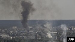 El humo y la suciedad se elevan desde la ciudad de Severodonetsk durante los combates entre las tropas ucranianas y rusas en la región de Donbás, en el este de Ucrania, el 14 de junio de 2022, en medio de la invasión rusa de Ucrania. (Foto de ARIS MESSINIS / AFP)