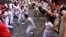 Gente corriendo por la calle con toros bravos y cabestros, en el primer día de encierros en las Fiestas de San Fermín en Pamplona, en el norte de España, el martes 7 de julio de 2022. (AP Foto/Álvaro Barrientos)