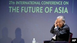 Mantan Perdana Menteri Malaysia Mahathir Mohamad membetulkan letak earphone-nya, sebelum menjawab pertanyaan pada sesi Konferensi Internasional tentang "Masa Depan Asia" di Tokyo, Jumat, 27 Mei 2022. (Foto AP/Eugene Hoshiko)
