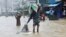 People wade through the water as they look for shelter during a flood, amidst heavy rains that caused widespread flooding in the northeastern part of the country, in Sylhet, Bangladesh, June 18, 2022.