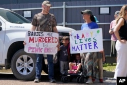 A family of abortion opponents stand outside the Jackson Women's Health Organization clinic in Jackson, June 25, 2022.