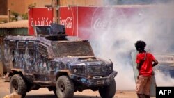 Un manifestant anti-coup d'État face à un véhicule des forces de sécurité lors de manifestations de masse dans le centre de Khartoum, le 30 juin 2022