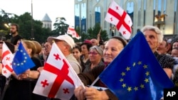 Demonstrators gather with Georgian national and EU flags during a pro-EU and anti-government rally, in front of the parliament building in Tbilisi, Georgia, July 3, 2022.