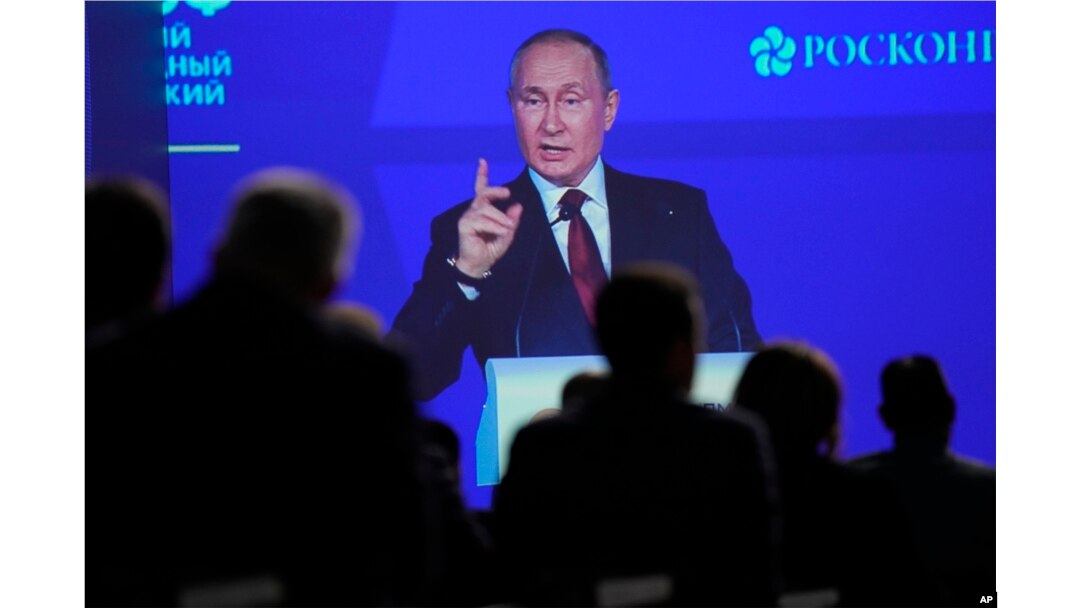 Participants watch as Russian President Vladimir Putin addresses a plenary session of the St. Petersburg International Economic Forum in St. Petersburg, June 17, 2022.