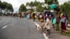 FILE - People walk on the road near Kibumba, north of Goma, Democratic Republic of the Congo, as they flee fighting between Congolese forces and M23 rebels in North Kivu, May 24, 2022.