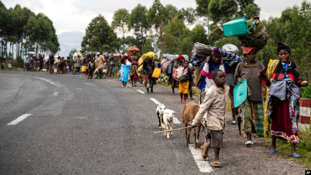 FILE - People walk on the road near Kibumba, north of Goma, Democratic Republic of the Congo, as they flee fighting between Congolese forces and M23 rebels in North Kivu, May 24, 2022.